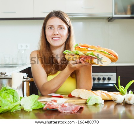 girl with cooked  spanish sandwiches (bocadillo) in home kitchen