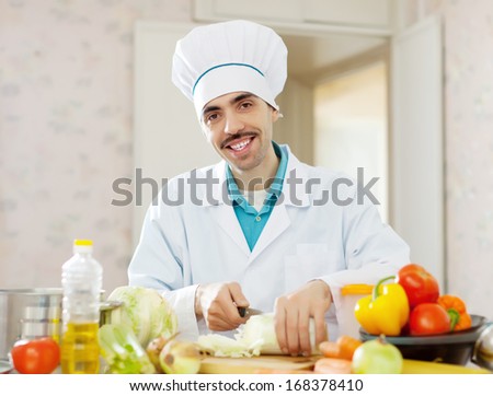 Happy chef cooking vegetarian lunch on cutting board