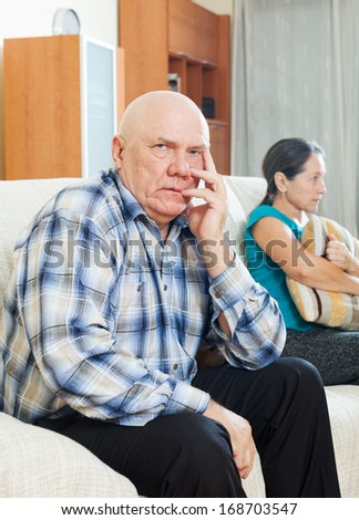 Family quarrel. Upset senior man against sad wife at home