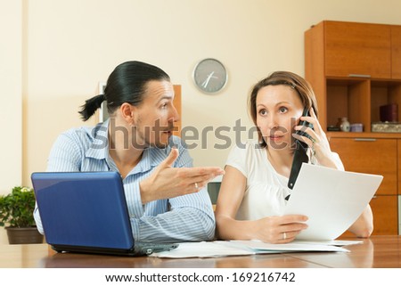 middle-aged Man and woman looking financial document at home