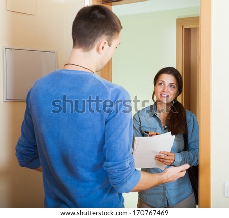 Smiling woman conducting  survey among people at door