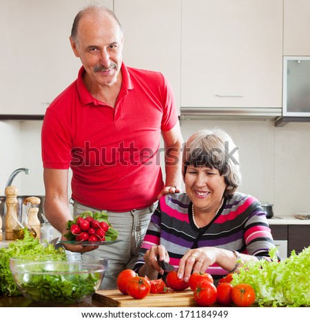 happy senior man and mature woman  cooking vegetables lunch