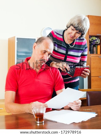 senior family  with financial documents at home interior