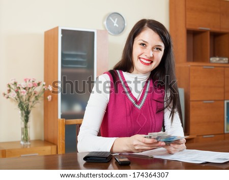 happy woman with money and documents  in home