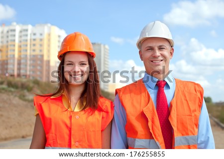 Portrait of two white-collar workers wearing protective helmet works on the building site