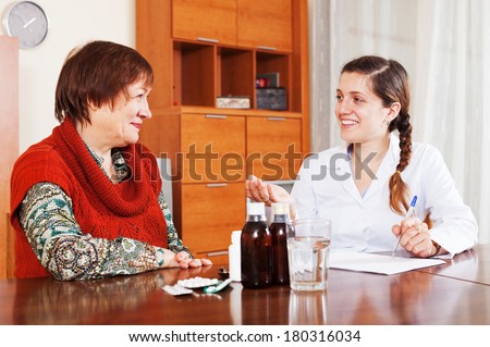 happy female doctor prescribing medication to mature woman at home. Focus on patient