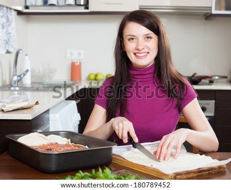 Smiling girl cooking  pie with store-bought dough at home