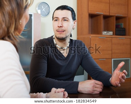 Ordinary man and woman talking in home interior