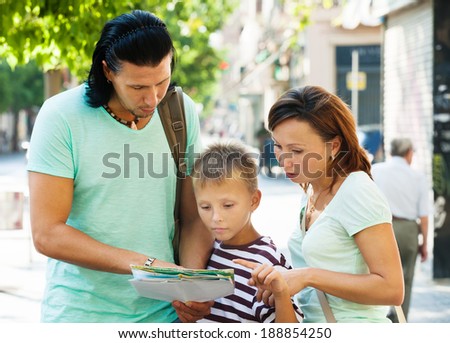 Traveling family  looking at the map in  city street