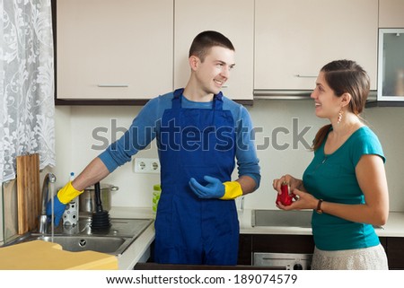 Adult plumber in  repairing a running water  for  girl