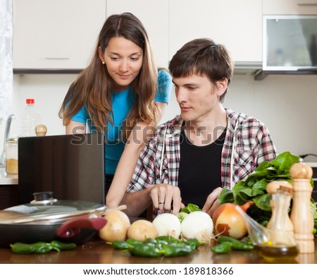 Family looking at notebook during cooking food at home kitchen