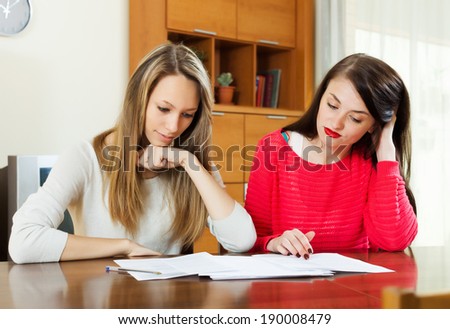 serious women with  documents at table