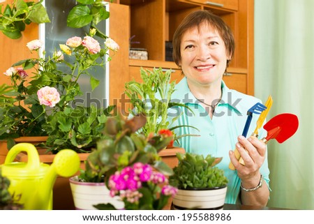 Female gardener caring for plants in pots in home