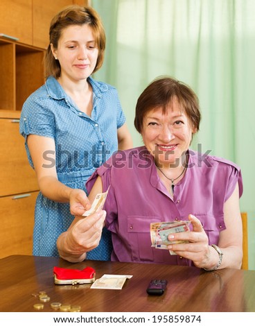 Smiling woman asking aged mother  the money for minor expenses at home