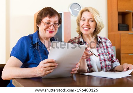 Two smiling colleagues discussing the contents of the documents