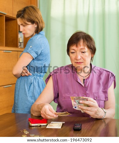 Family having financial problems and mother counting money at the table