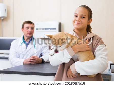 Happy teen girl led dog for examination by a veterinarian. High quality photo Stock fotó © 