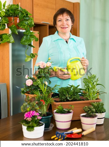 mature woman taking care of her small garden  at home