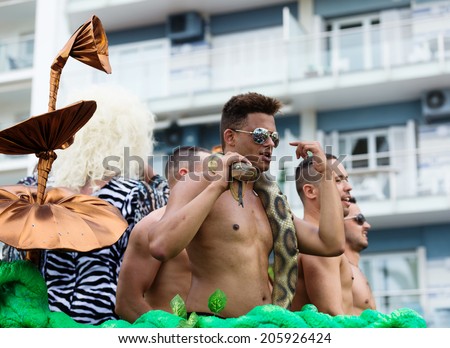 SITGES, SPAIN - JUNE 15, 2014: People are surrounded by strange mushrooms with snakes at Gay pride parade in Sitges
