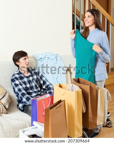 Happy guy and girl with purchases in home