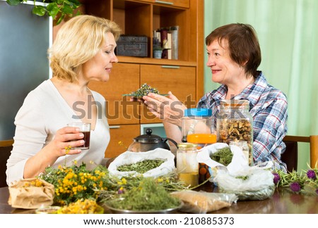 Mature woman explaining to her neighbor about the properties of herbal tea