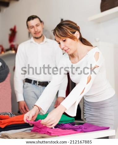Ordinary couple choosing clothes at fashion shop