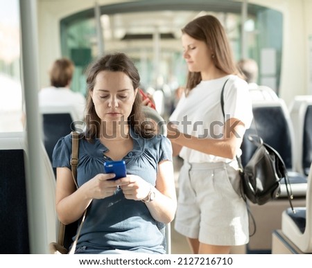 Woman using mobile phone in the cabin of a bus or tram. High quality photo ストックフォト © 