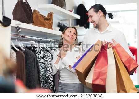 Young couple choosing clothes together at fashion boutique