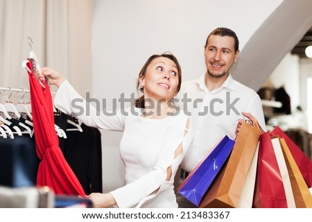 Nice couple choosing clothes at clothing store