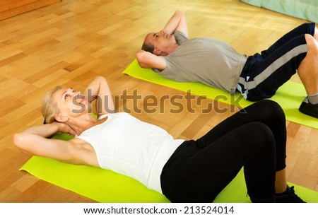 Positive pensioners doing morning exercises indoor
