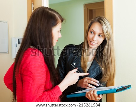 Woman answer questions of social worker with papers at door at home