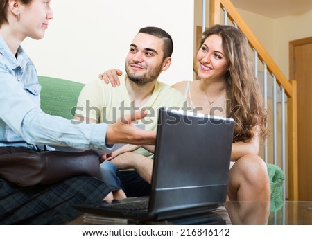 Happy couple answer questions of social worker at home