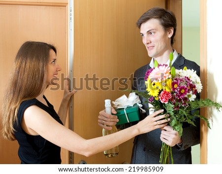 Nice man giving gifts to woman at home