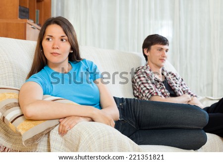 Family quarrel. Sad guy and girlfriend after quarrel  in living room at home