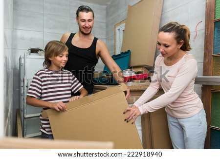 Friendly family of three packing things before relocation
