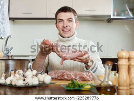 Ordinary guy cooking french-style meat at kitchen