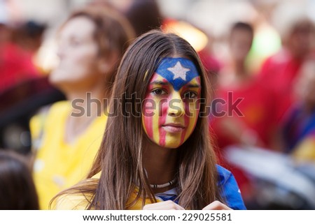 BARCELONA, SPAIN - SEPTEMBER 11, 2014: Unidentified Catalan young woman making Catalan Flag on face and waiting  rally to National Day of Catalonia