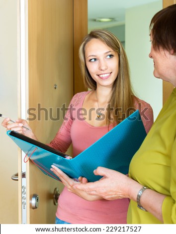 Mature woman answer the questions of the social worker at home