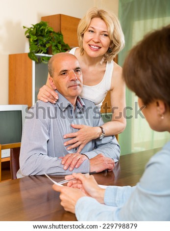 Senior mature couple filling questionnaire for employee at home
