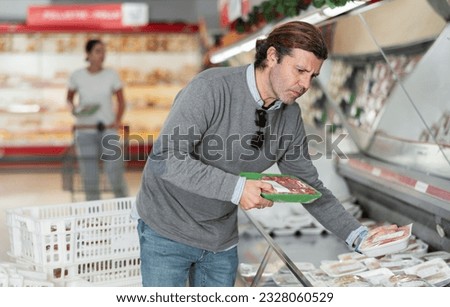 Man choosing meat in grocery store