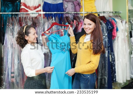 Two women chooses evening gown at clothing store