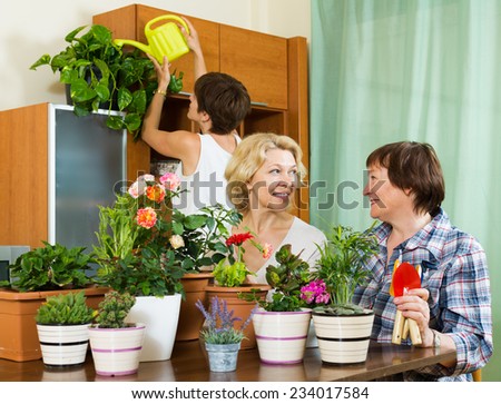 pensioners  and girl  watering decorative plants and smiling