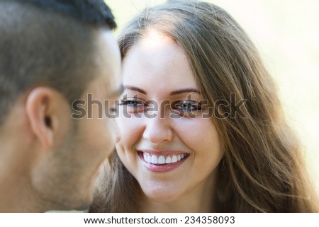 Close-up portrait of young girl and her boyfriend laughing in summer park