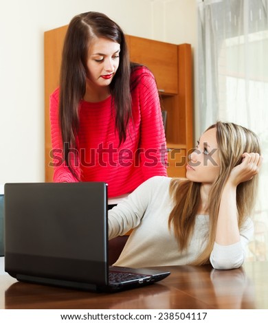 serious girls at table with computer at office