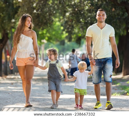 Russian family with children holding vacation day and smiling in park