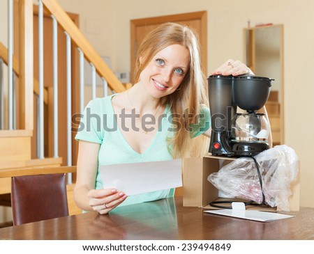 Woman with new electric coffee maker at home