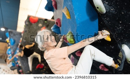 Similar – Image, Stock Photo Woman rock climbing indoors.