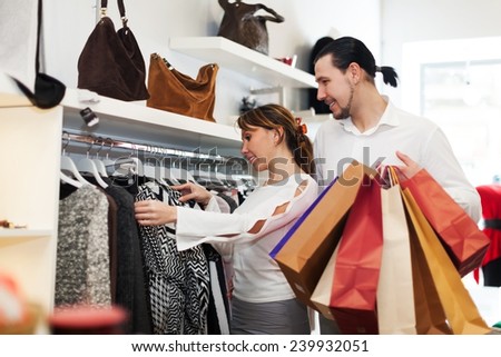 Young couple choosing clothes at fashion market together