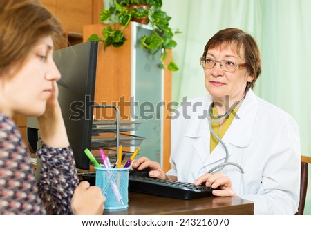 elderly doctor advises female patient in office