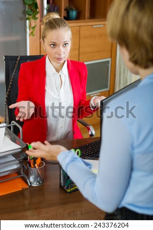 young nervous boss arguing with female employee at office